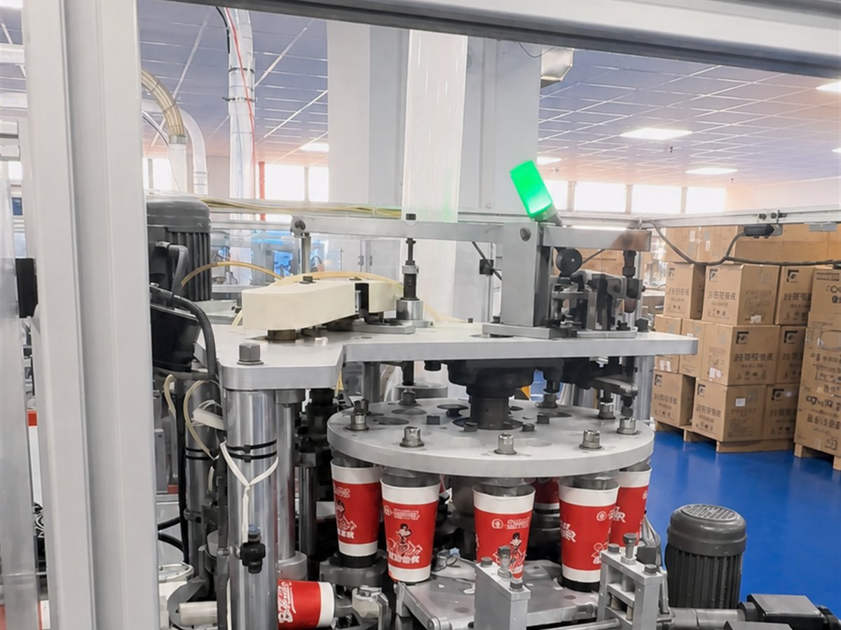 Paper cups being formed on automated production equipment